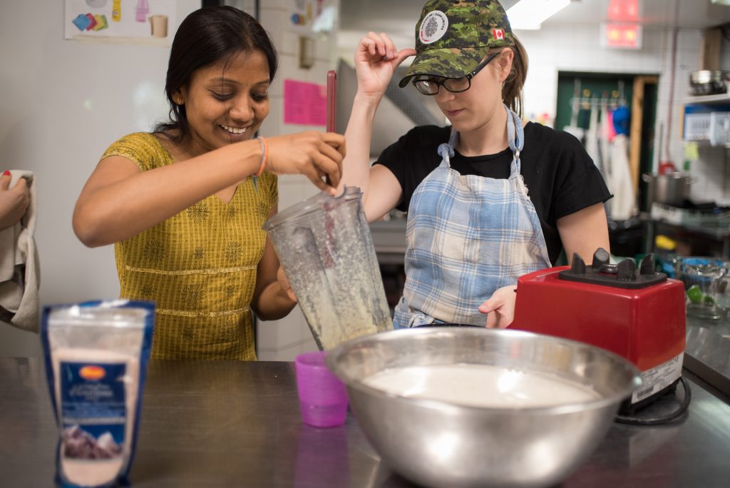 Des participantes préparent un repas ensemble lors d’un atelier de cuisine culturelle au Dépôt.