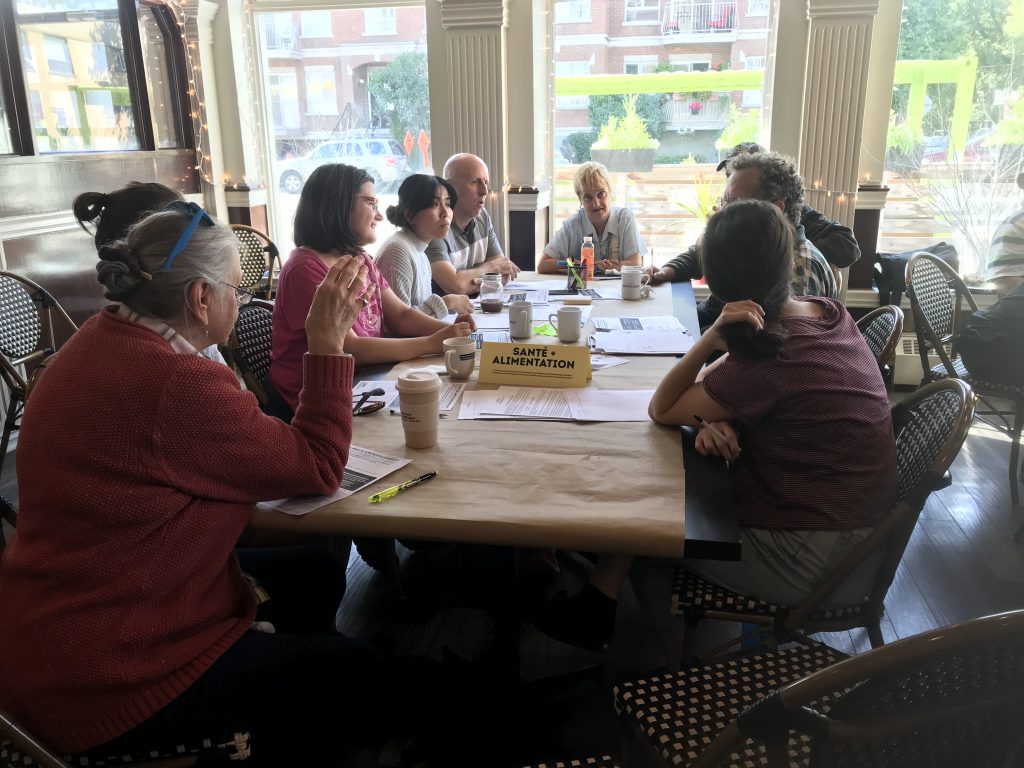 Community members speaking with election candidates during a 2018 Eat Think Vote event at The Depot about food insecurity and community priorities.