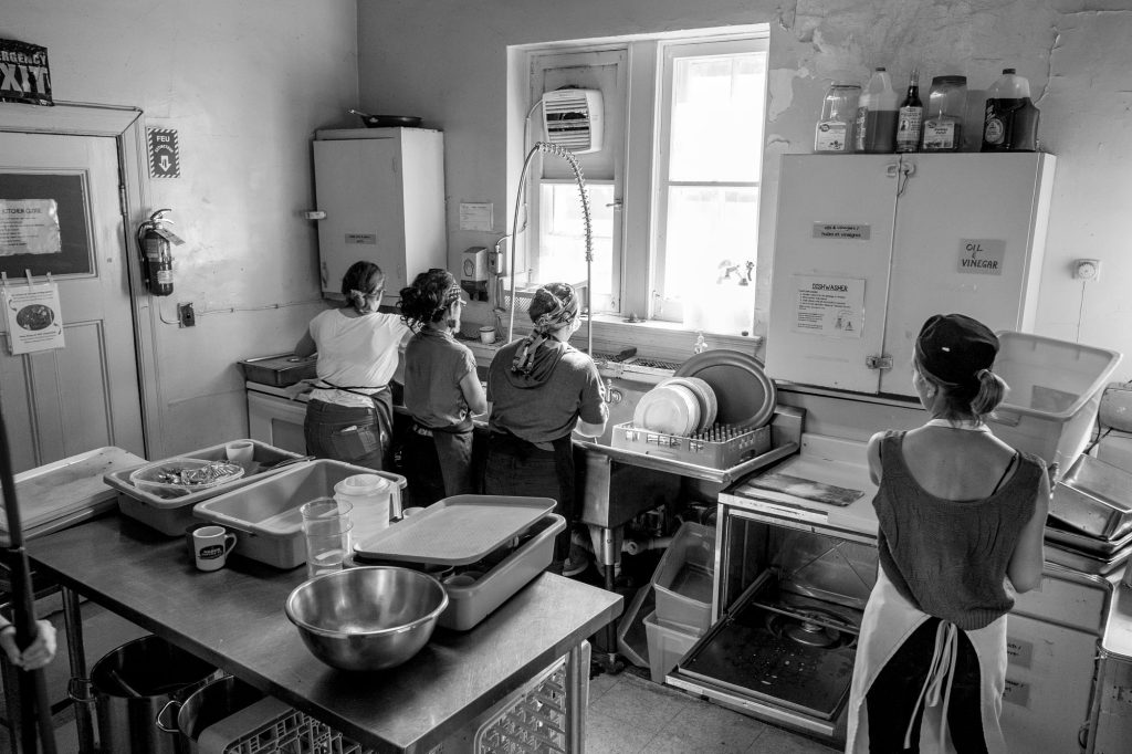 Volunteers wash dishes in the small kitchen used for The Depot's community meal program in the basement of Trinity Church.