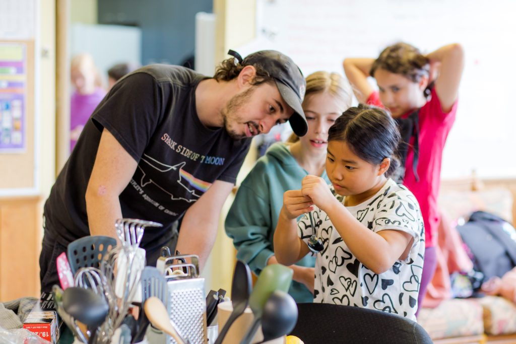 An animator supports a participant to select the right measuring spoon at a Boîte à Lunch workshop